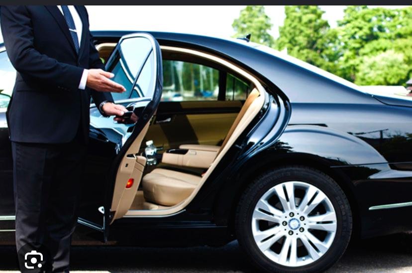 Chauffeur opening the door of a black executive car for private hire